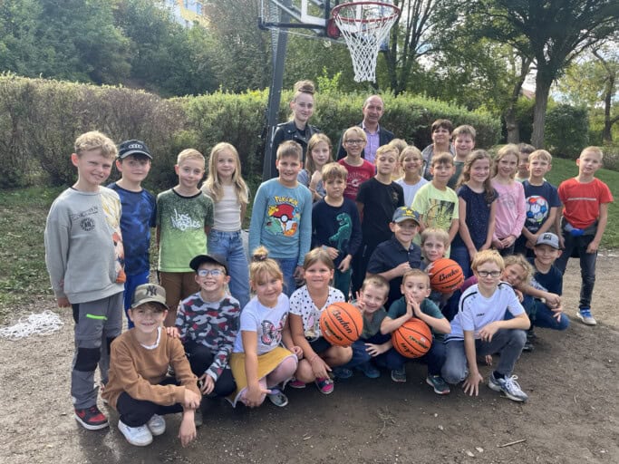 Foto mit einigen Kindern und Erziehern von der Übergabe des Basketballkorbes an den Hort Glück-Auf in Zauckerode. Foto: WGF